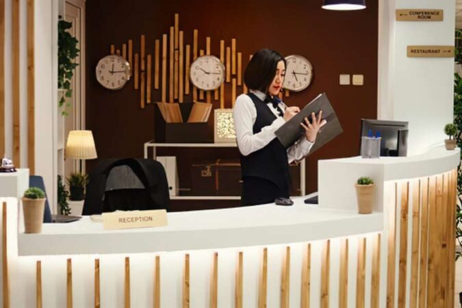Une réceptionniste travaille au comptoir d'accueil lors du recueil des avis clients sur l'hôtel.
